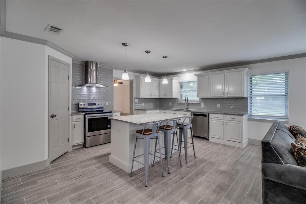 702 Ridgedale Drive Garland, TX 75041 - Photo 10 of 23 a kitchen with stainless steel appliances kitchen island granite countertop a stove a sink and a refrigerator