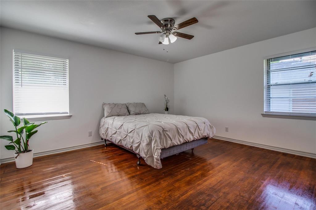 702 Ridgedale Drive Garland, TX 75041 - Photo 11 of 23 a bedroom with a large bed chandelier and a window