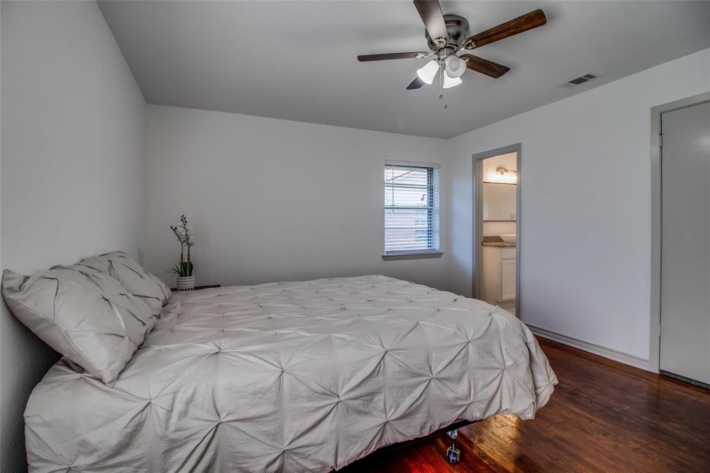 702 Ridgedale Drive Garland, TX 75041 - Photo 14 of 23 a bedroom with a bed and a chandelier