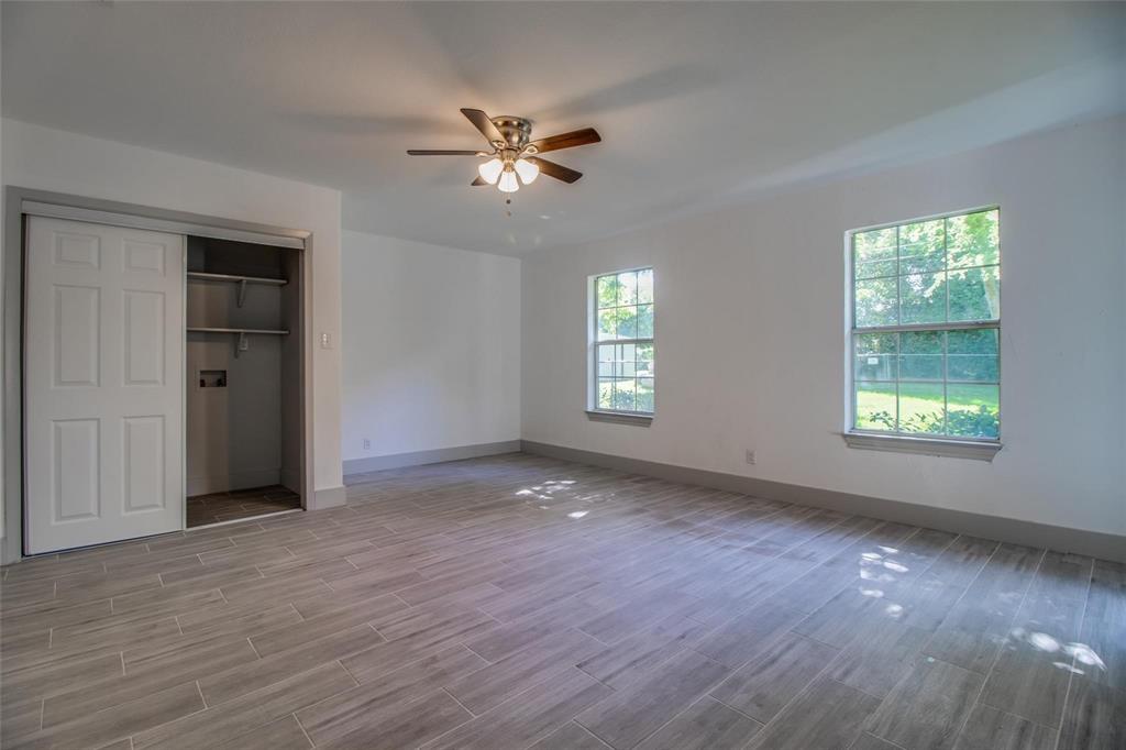 702 Ridgedale Drive Garland, TX 75041 - Photo 19 of 23 a view of an empty room with a window and wooden floor