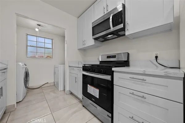 a kitchen with stainless steel appliances a stove microwave and sink