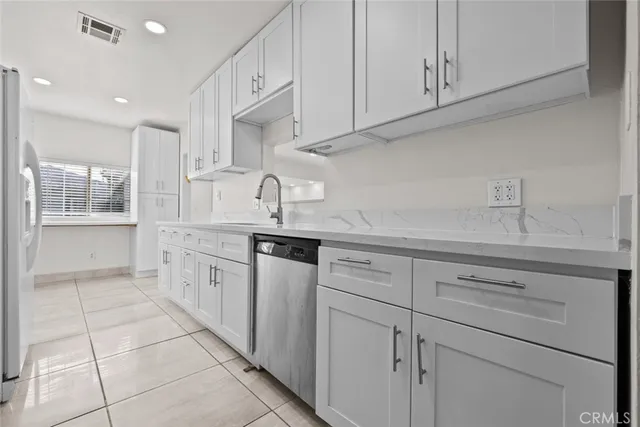 a kitchen with white cabinets and appliances