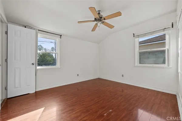a view of a big room with wooden floor and windows