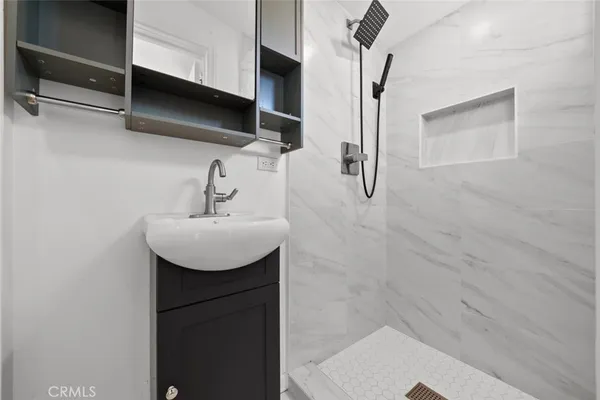 a bathroom with a sink a mirror and shower