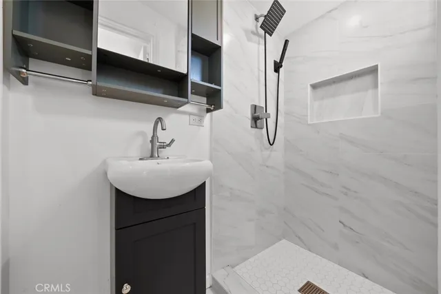 a bathroom with a sink a mirror and shower