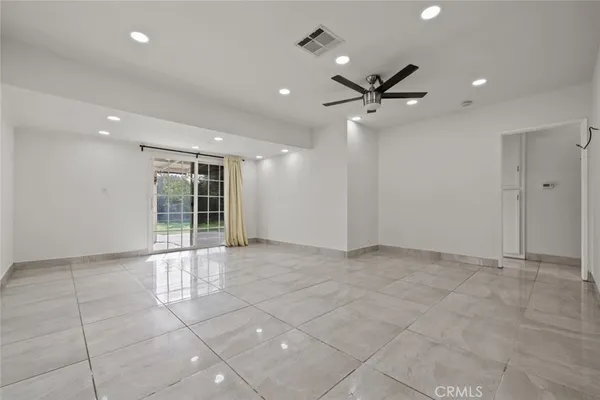 an empty room with chandelier and windows