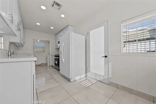 a view of a kitchen with a sink and a refrigerator