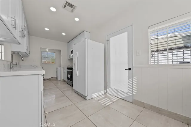 a view of a kitchen with a sink and a refrigerator