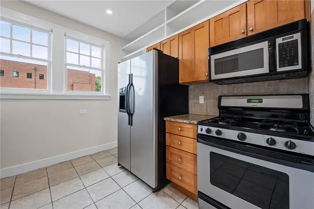 a kitchen with stainless steel appliances a stove a microwave and a refrigerator
