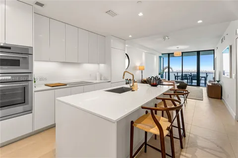 a kitchen with a sink a stove and chairs