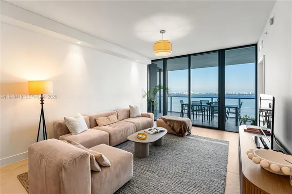 a living room with furniture and a floor to ceiling window