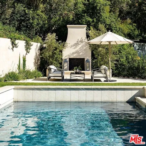 a view of a swimming pool with a yard and sitting area