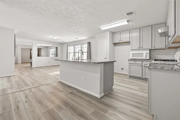 a kitchen with stainless steel appliances granite countertop a stove a sink and a refrigerator