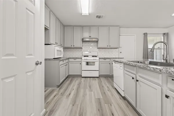 a kitchen with cabinets a sink and appliances