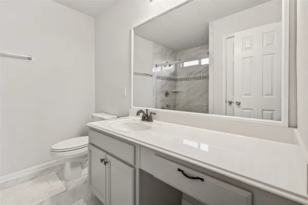 a bathroom with a sink a toilet and a mirror