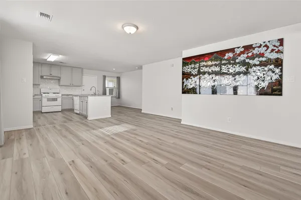 a view of a kitchen with wooden floor and a window