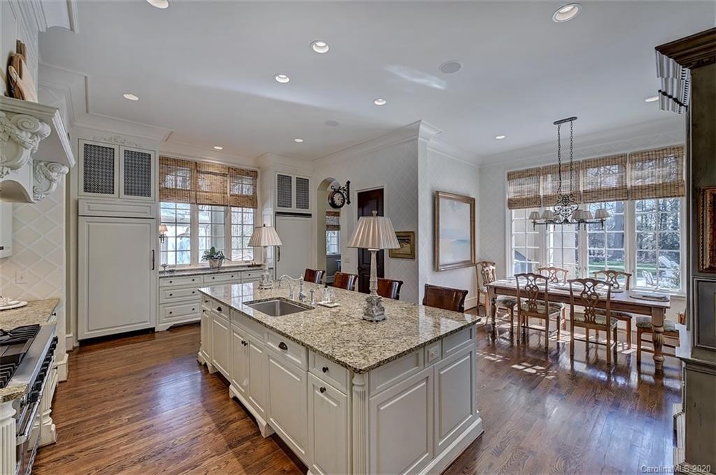 6256 Sharon Hills Road Charlotte, NC 28210 - Photo 11 of 45 a kitchen with granite countertop center island wooden floor and stainless steel appliances