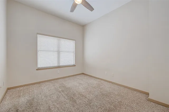 an empty room with closet and a chandelier fan