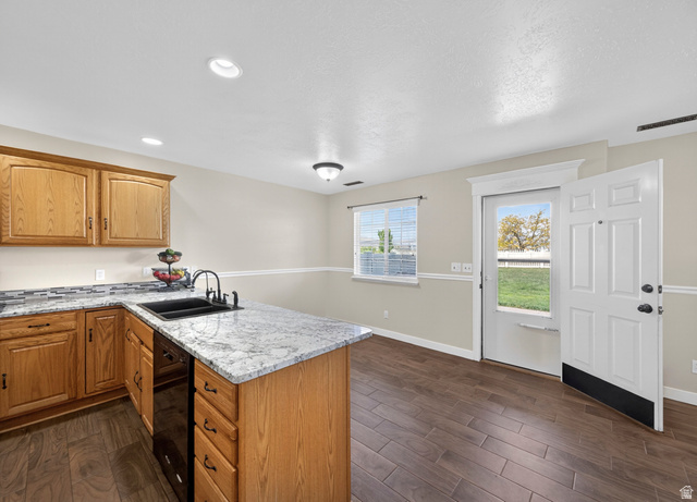 802 Sugar Maple Court Payson, UT 84651 - Photo 10 of 30 Kitchen with a peninsula, dark wood-style floors, light stone countertops, dishwasher, and wood finish cabinets