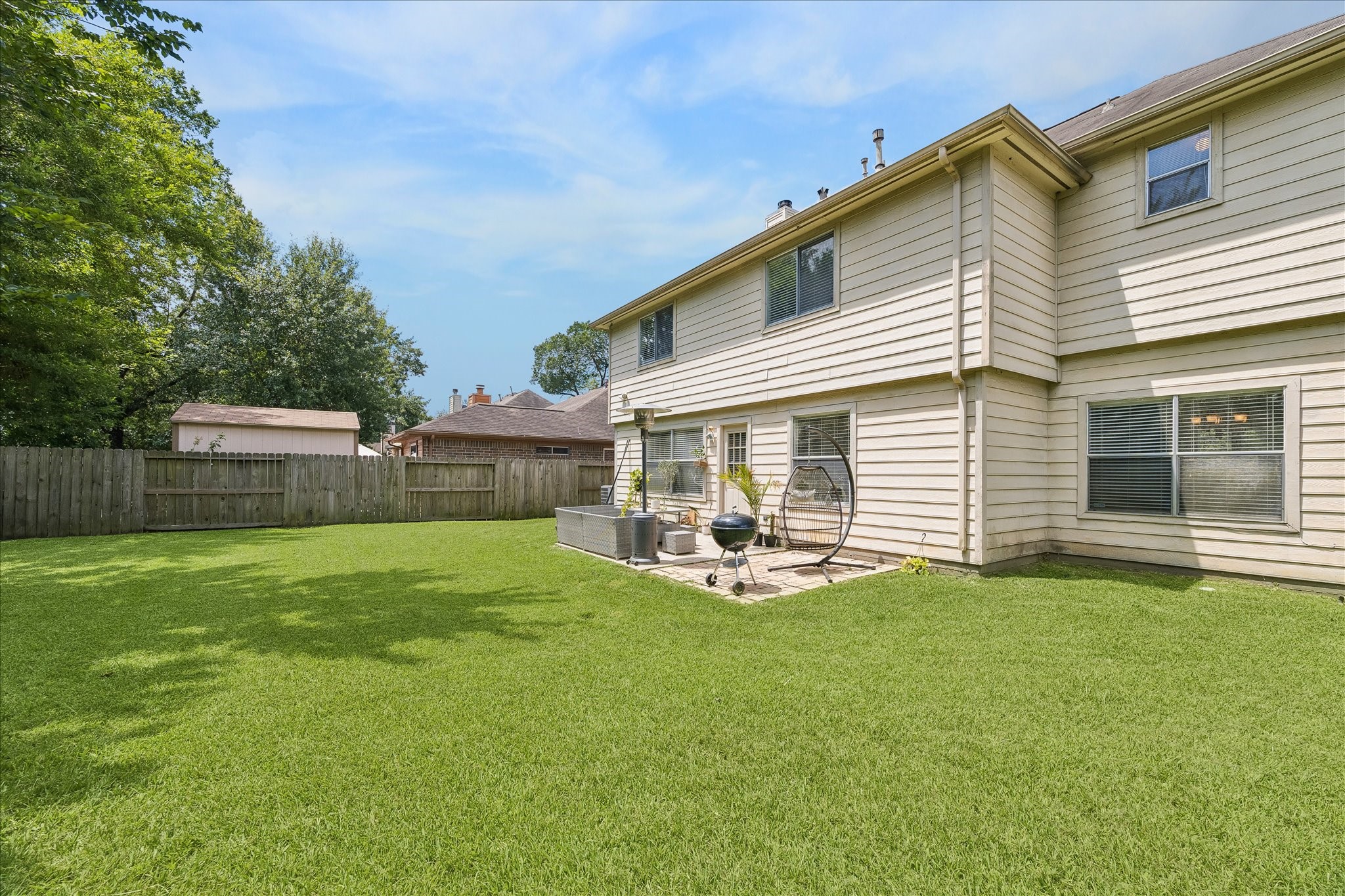 23234 Grand Rapids Lane Spring, TX 77373 - Photo 29 of 30 Expansive, fully fenced backyard offers a lush lawn and a private patio retreat — ideal for relaxing or entertaining outdoors.