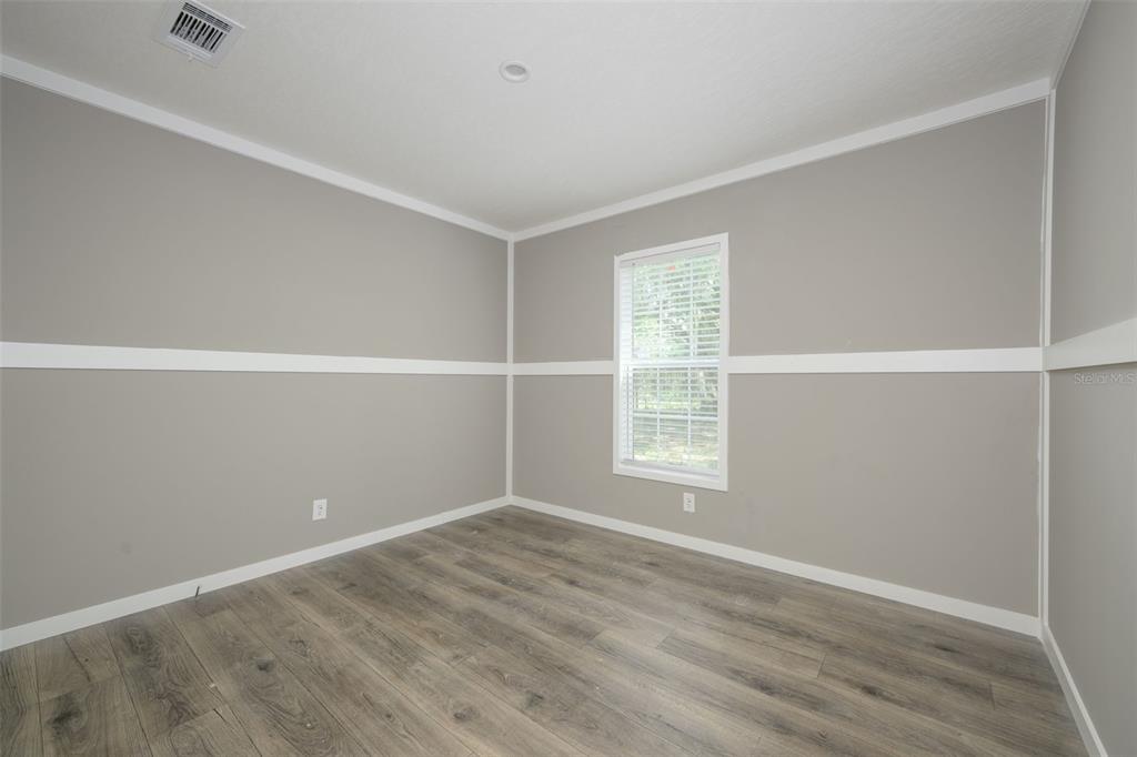 374 Sisco Road Pomona Park, FL 32181 - Photo 16 of 40 an empty room with wooden floor and windows