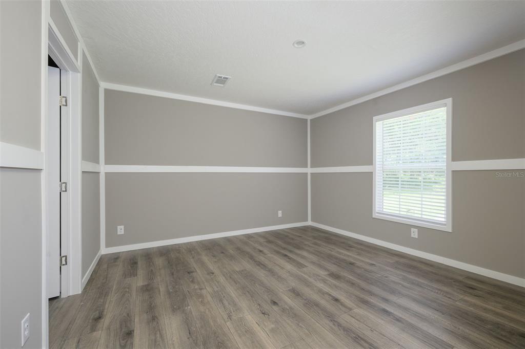 374 Sisco Road Pomona Park, FL 32181 - Photo 17 of 40 an empty room with wooden floor and windows