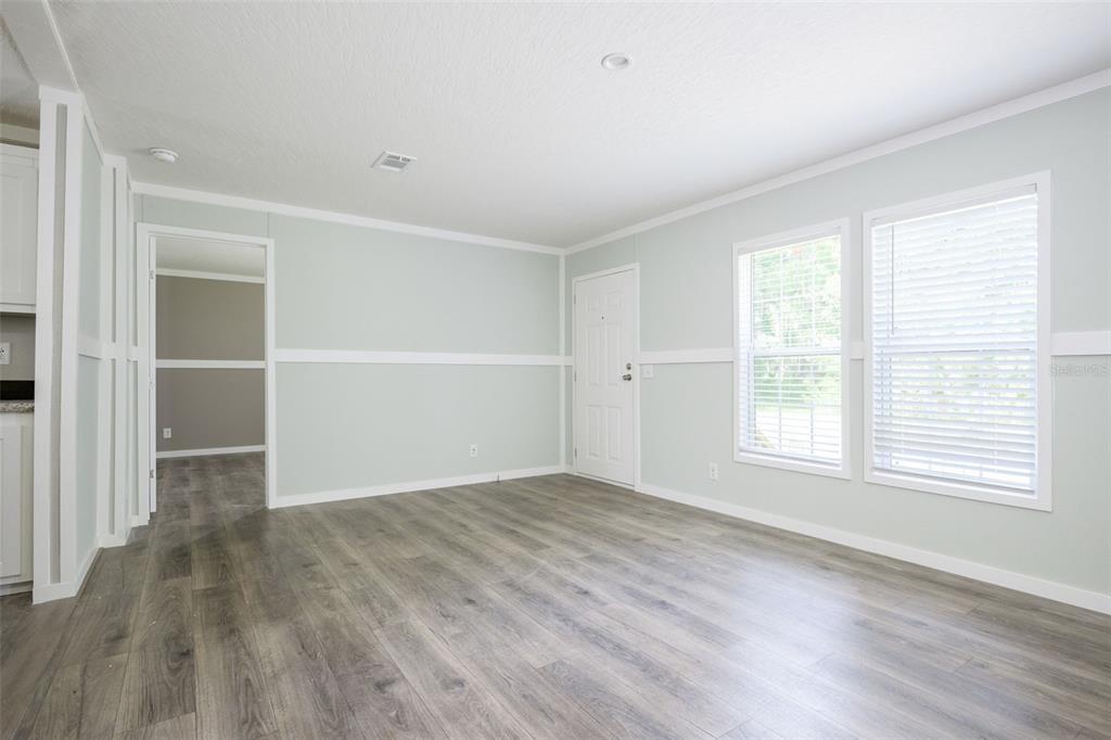 374 Sisco Road Pomona Park, FL 32181 - Photo 3 of 40 an empty room with wooden floor and windows