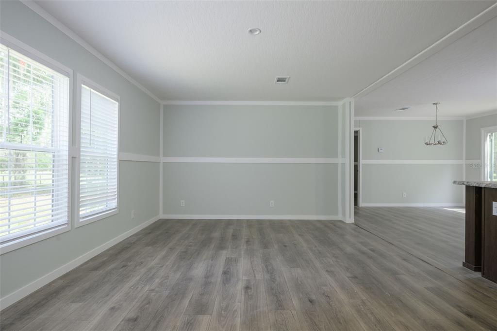 374 Sisco Road Pomona Park, FL 32181 - Photo 5 of 40 an empty room with wooden floor and windows