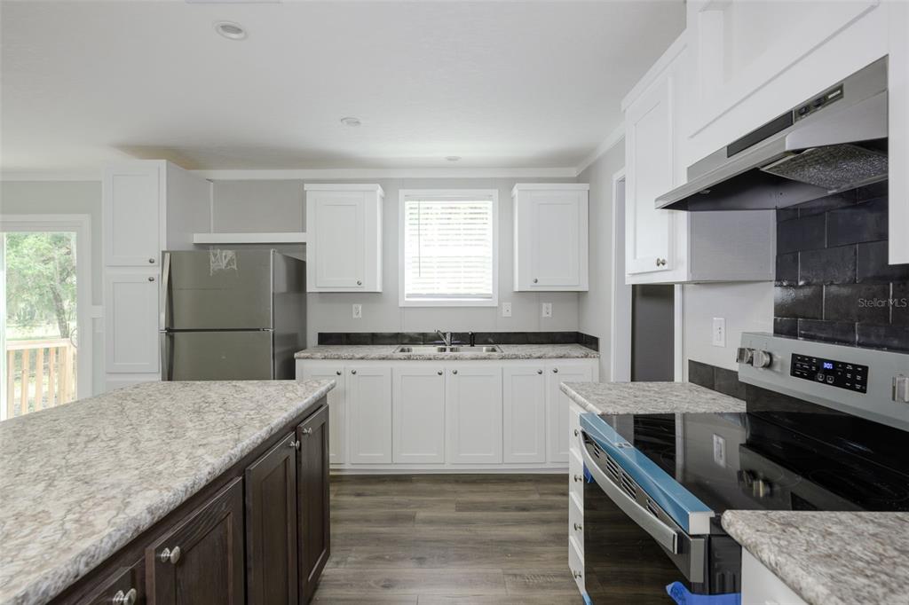 374 Sisco Road Pomona Park, FL 32181 - Photo 6 of 40 a kitchen with stainless steel appliances granite countertop a stove refrigerator sink and microwave