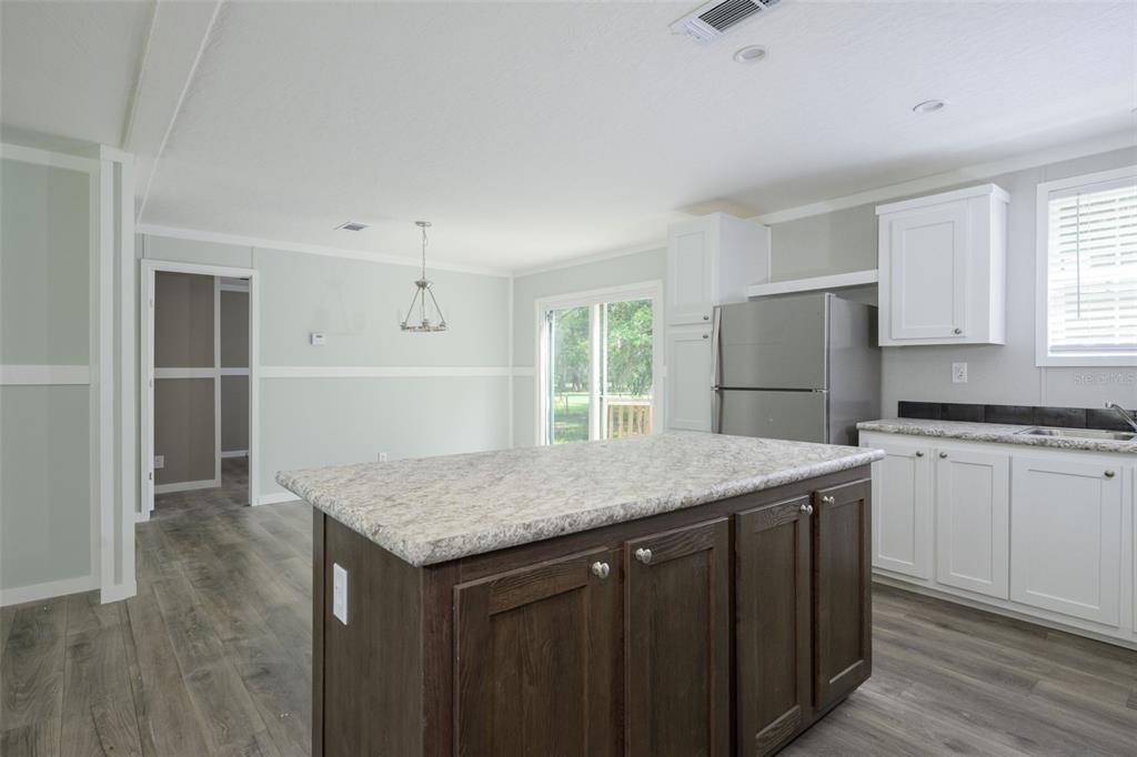 374 Sisco Road Pomona Park, FL 32181 - Photo 8 of 40 a kitchen with a granite countertop sink refrigerator and cabinets