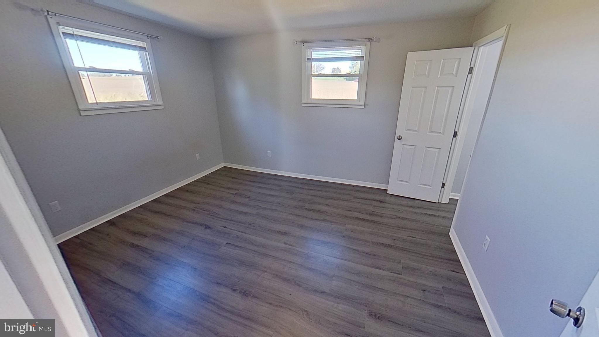 490 Windsor Street, Unit B Red Lion, PA 17356 - Photo 13 of 15 an empty room with wooden floor and windows