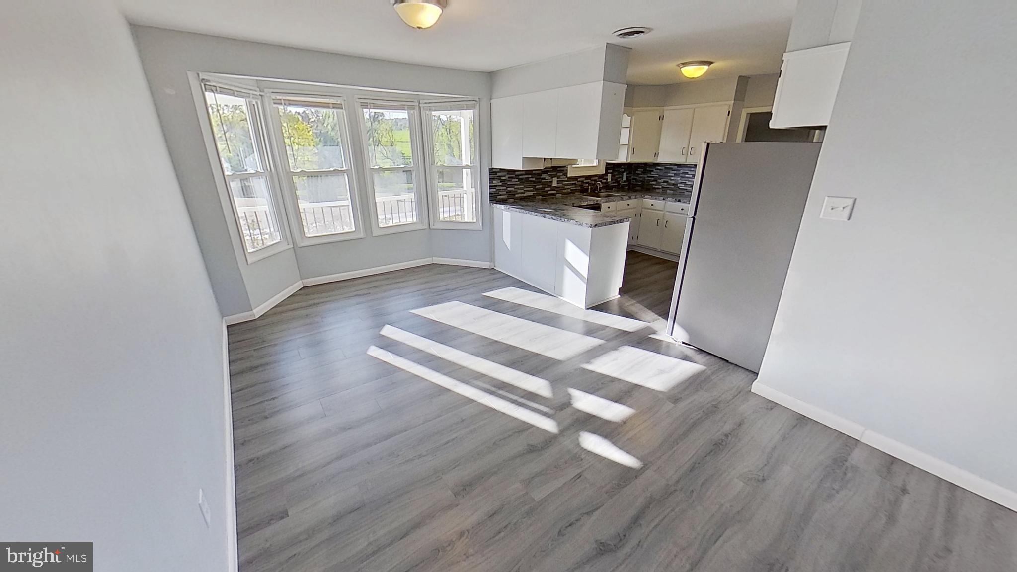 490 Windsor Street, Unit B Red Lion, PA 17356 - Photo 5 of 15 a living room with stainless steel appliances furniture a refrigerator a sink a window and cabinets