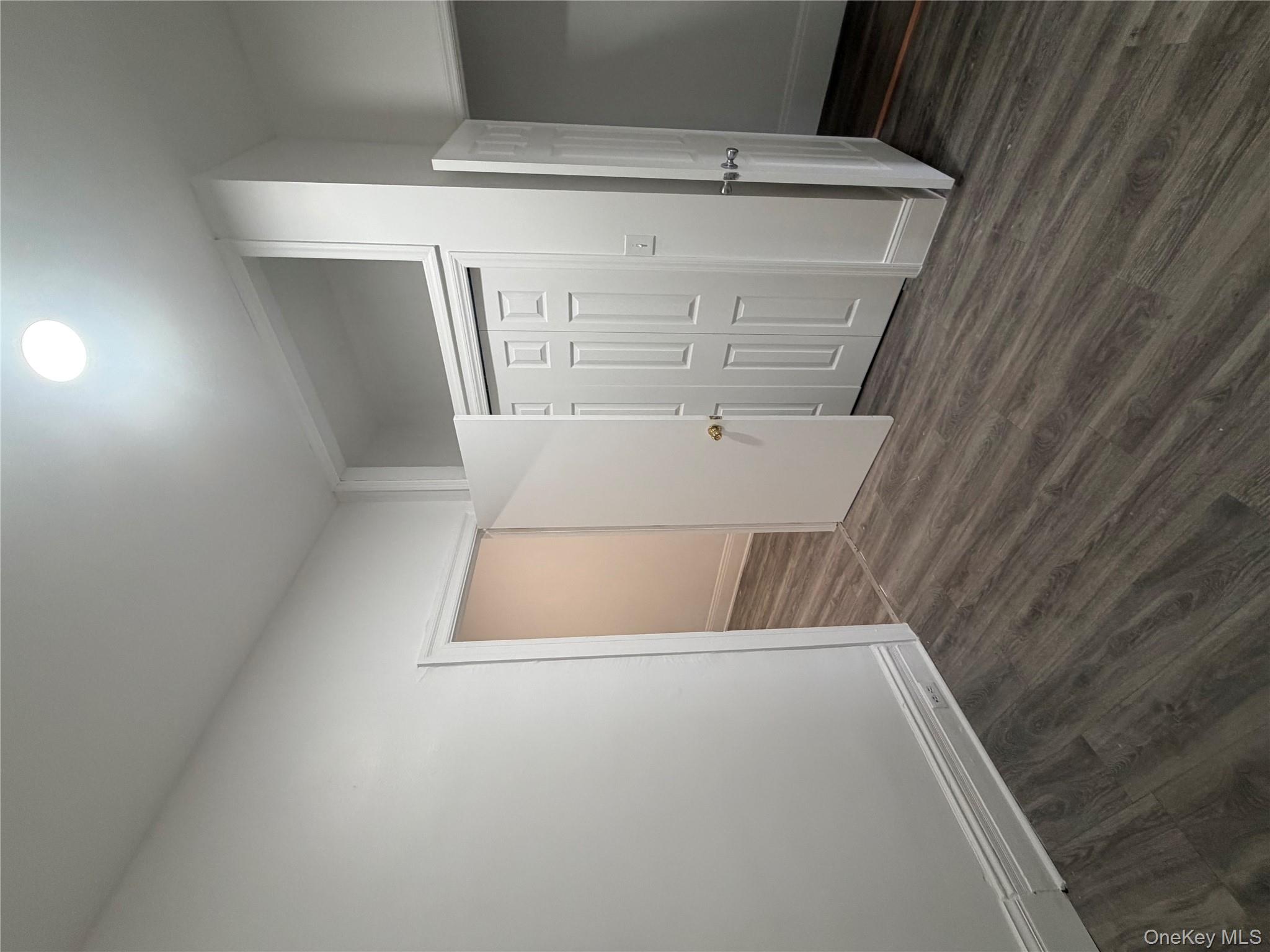 88 Cornelia Street Brooklyn, NY 11221 - Photo 4 of 8 an empty room with wooden floor & bathroom space