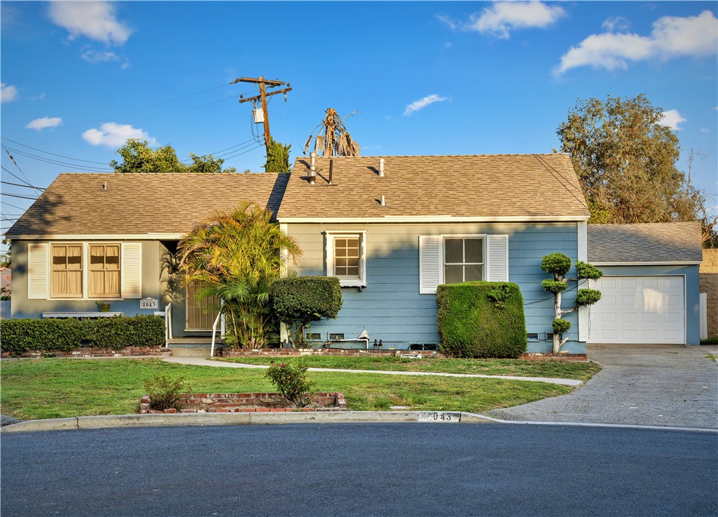 a front view of a house with a garden and plants