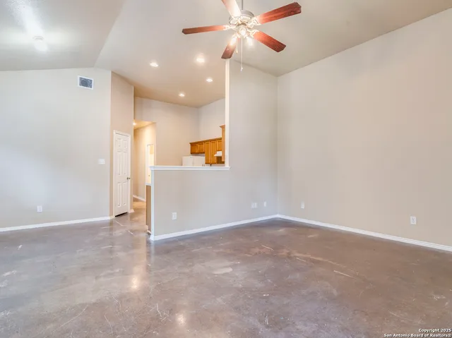 an empty room with a ceiling fan and a window