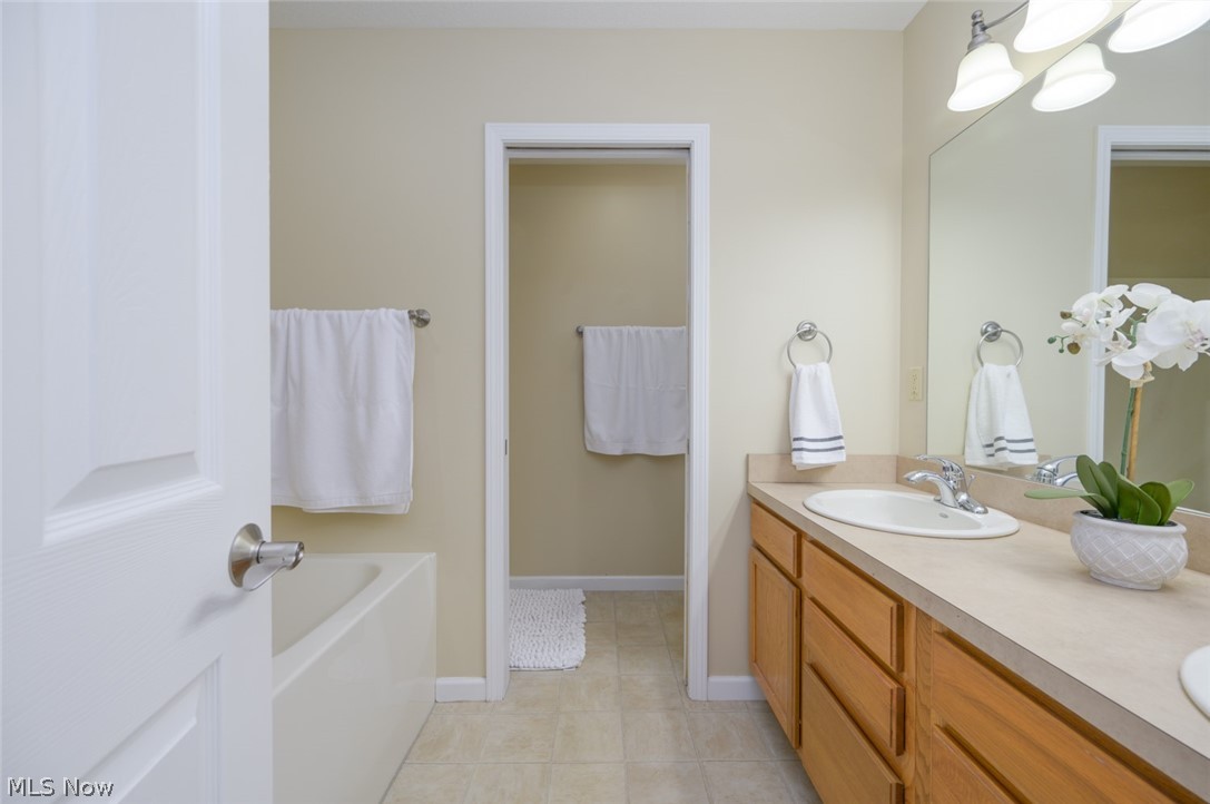 1060 Susan Road Ravenna, OH 44266 - Photo 16 of 25 Bathroom featuring tile flooring, a bath, and dual vanity