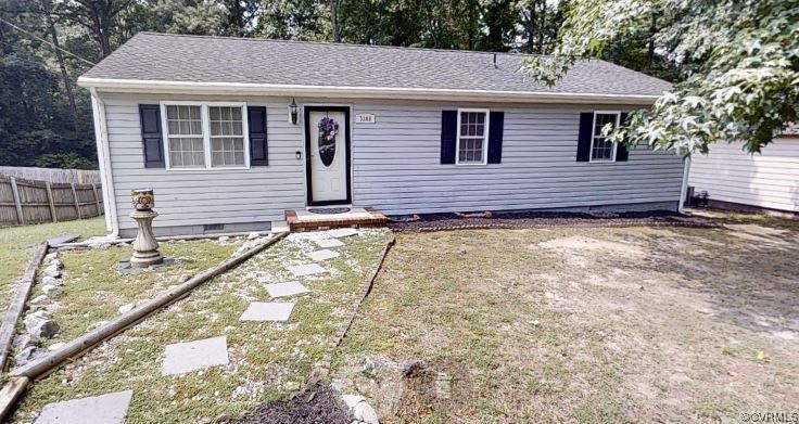 a view of a house with a small yard and a large tree