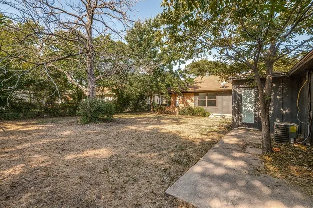 a front view of a house with a yard and large trees