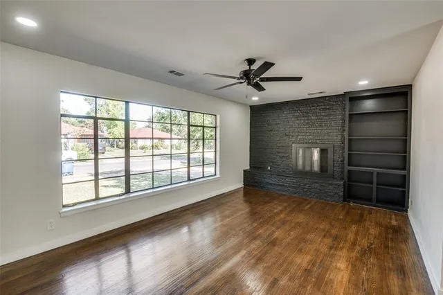 a view of a hallway with wooden floor and a fireplace