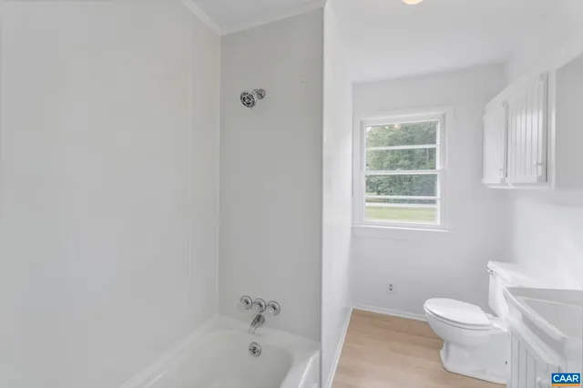 a white toilet sitting next to a bath tub