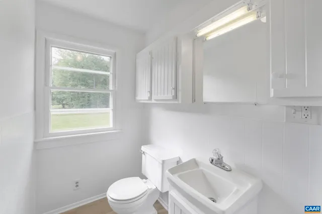 a bathroom with a sink a toilet and a window