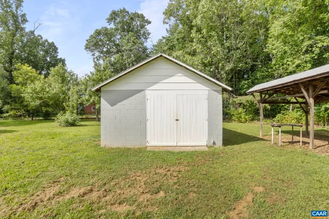 a view of a backyard with large trees and plants