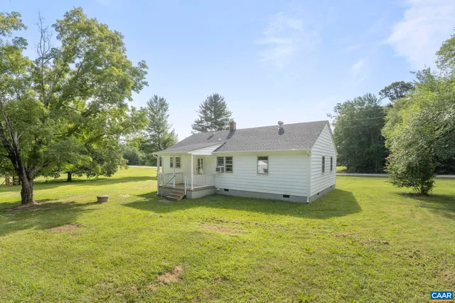 a view of a house with a big yard and large tree