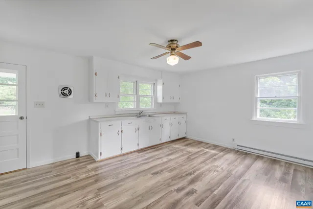 a view of empty room with wooden floor and window