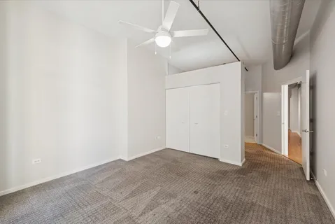 an empty room with a ceiling fan and bathroom