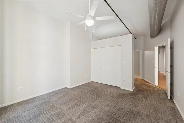 an empty room with a ceiling fan and bathroom