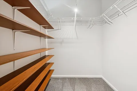a view of walk in closet with wooden floor