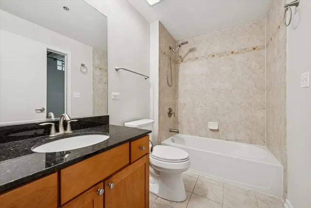 a bathroom with a granite countertop sink toilet mirror and shower