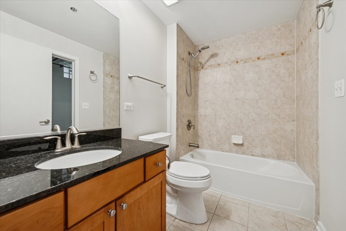 520 South State Street, Unit 907 Chicago, IL 60605 - Photo 20 of 26 a bathroom with a granite countertop sink toilet mirror and shower