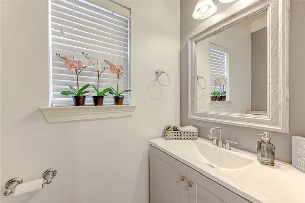 a bathroom with a sink mirror and window